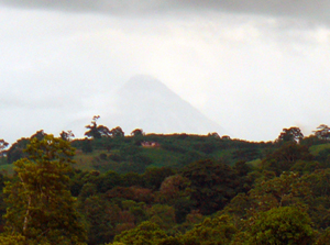 Arenal Volcano barely shows itself while clouds move past.